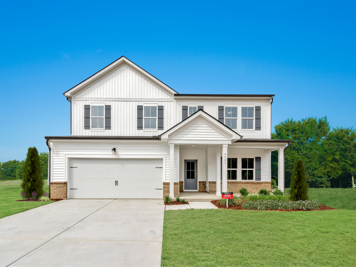 white farmhouse style new construction and blue sky